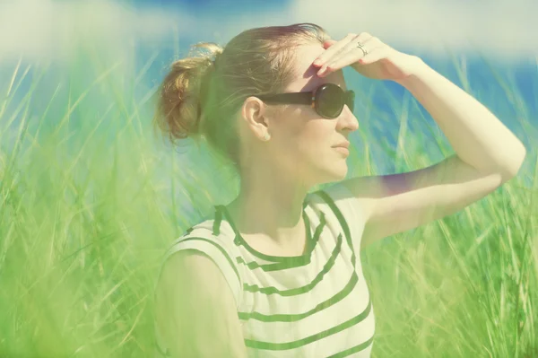 Junge Frau sitzt in Sanddünen inmitten von hohem Gras und genießt die Aussicht an sonnigen Tagen, Luskentyre, Insel Harris, Schottland — Stockfoto