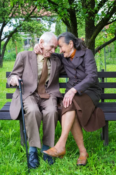 Söta 80 plus år gammal gift par poserar för ett porträtt i deras trädgård. Love forever koncept. — Stockfoto