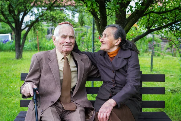 Nettes 80-jähriges Ehepaar posiert für ein Porträt in seinem Garten. Liebe für immer. — Stockfoto