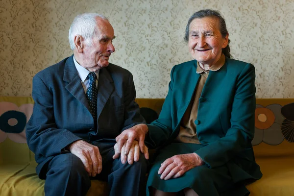 Söta 80 plus år gammal gift par poserar för ett porträtt i deras hus. Love forever koncept. — Stockfoto