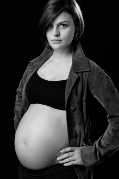 Attractive young pregnant woman with naked belly on black background — Stock Photo, Image