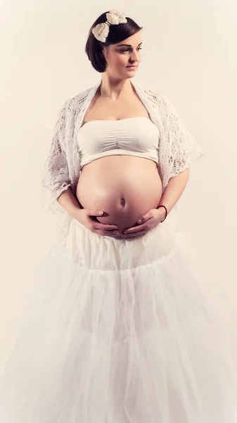 Attractive young pregnant woman with naked belly on white background smiling — Stock Photo, Image