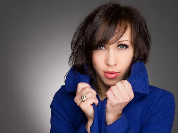 Horizontale kleurenafbeelding van een mooie jonge vrouw diep in gedachten. Het dragen van donker blauwe winterjas. Studio portret — Stockfoto