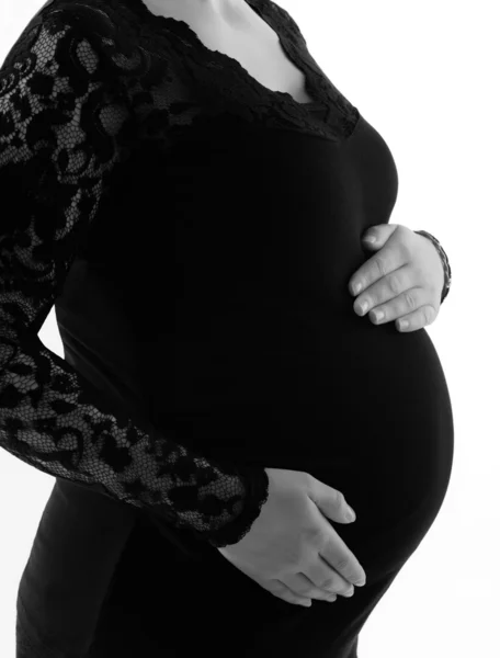 Immagine di una donna incinta che si tocca la pancia con le mani, vista laterale, su sfondo bianco — Foto Stock