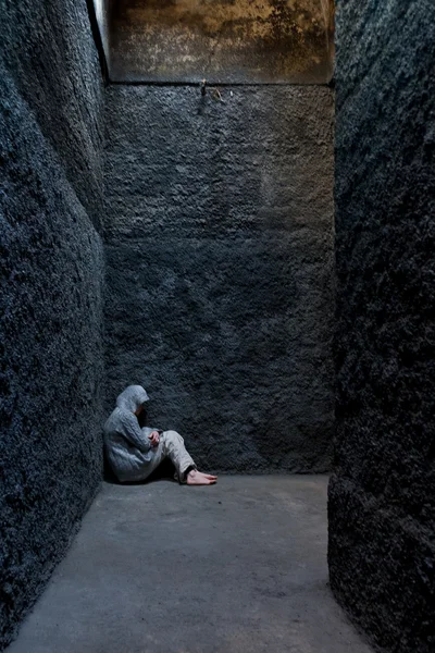 Scared, insane woman hiding in a corner of an ancient building. — Stock Photo, Image