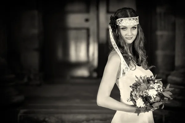 Beautiful Happy bride with wedding flowers bouquet in white dress with wedding hairstyle and makeup. Smiling woman in wedding dress waiting for groom. Pretty brunette girl bride. Jewelry and Beauty