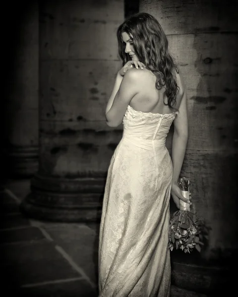 Όμορφη νύφη ευτυχισμένη με μπουκέτο λουλούδια γάμου σε λευκό φόρεμα με το χτένισμα του γάμου και μακιγιάζ. Χαμογελαστή γυναίκα στο νυφικό αναμονή για γαμπρό. Όμορφη μελαχρινή κοπέλα νύφη. — Φωτογραφία Αρχείου