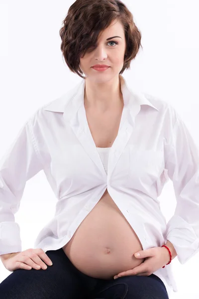 Attractive young pregnant woman with naked belly on white background Royalty Free Stock Photos