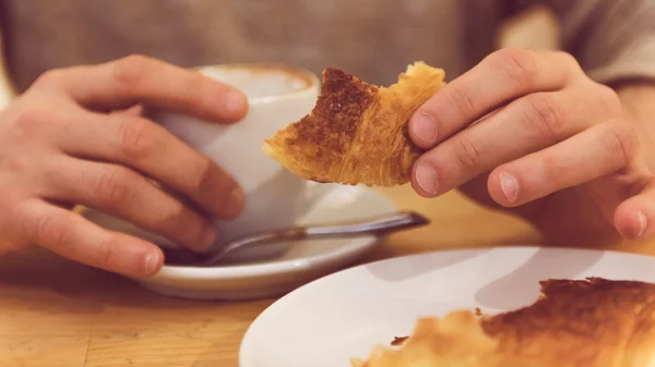 Szczegółowy obraz człowieka nie do poznania o śniadanie, jedzenie świeże ciasta. — Zdjęcie stockowe