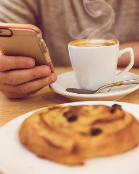 常にタッチ。コーヒーを飲みながら、レストランで朝食をとりながらスマート フォンを押し認識できない人間の詳細画像. — ストック写真