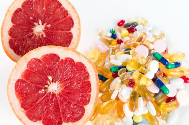 Pembe greyfurt ve hap, kopya alanı, sağlıklı beslenme kavramı ile beyaz zemin üzerine vitamin Takviyeler