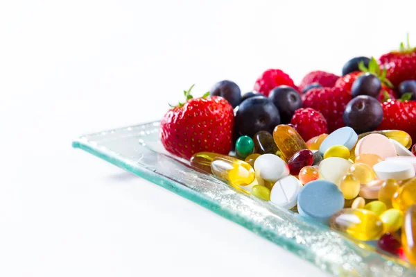 Здоровый образ жизни, концепция диеты, фрукты и таблетки, витаминные добавки с копированием пространства на белом фоне — стоковое фото