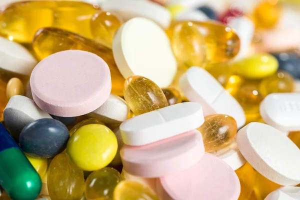 Крупным планом лекарственные препараты, таблетки и капсулы в капсулах и таблетках на белом фоне — стоковое фото