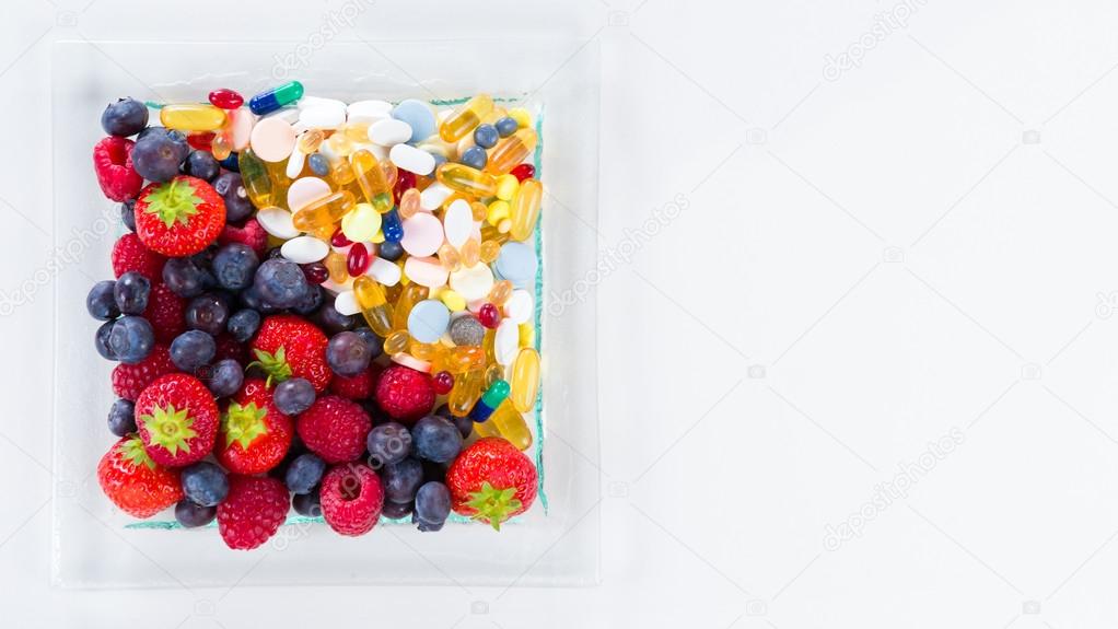 Healthy lifestyle, diet concept, Fruit and pills, vitamin supplements with copy space on white background