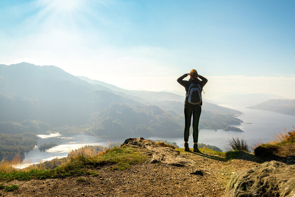 Female hiker on top of the mountain enjoying valley view, Ben A'an, Loch Katrine, Highlands, Scotland, UK