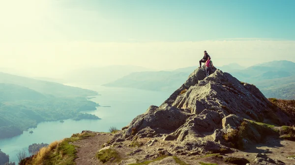 Two female hikers on top of the mountain enjoying valley view, Ben A'an, Loch Katrine, Highlands, Scotland, UK — Stock Photo, Image