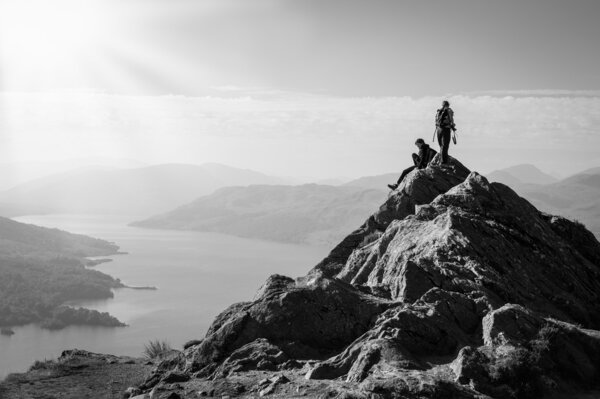 Two female hikers on top of the mountain enjoying valley view, Ben A'an, Loch Katrine, Highlands, Scotland, UK