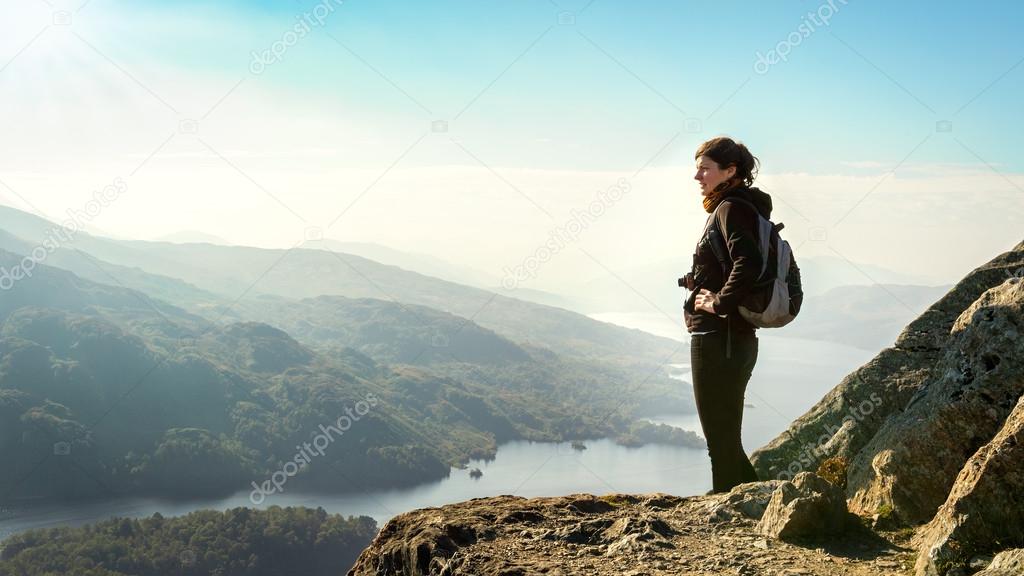Female hiker on top of the mountain enjoying valley view, Ben A'an, Loch Katrine, Highlands, Scotland, UK