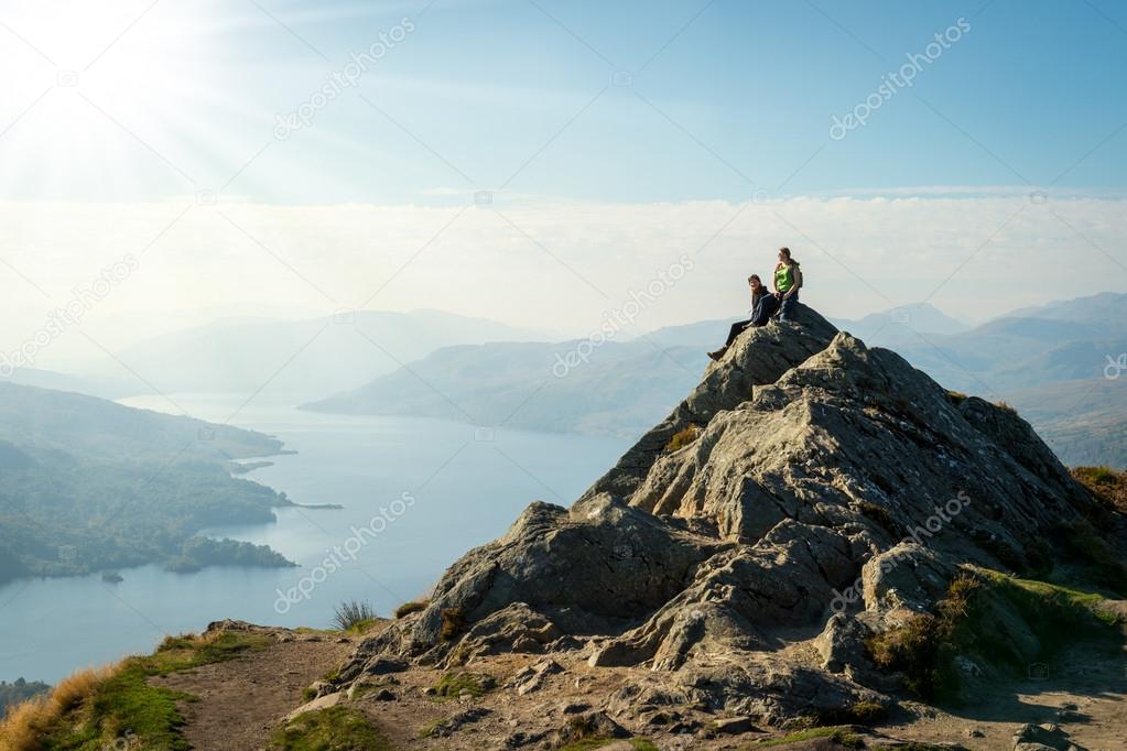 Two female hikers on top of the mountain enjoying valley view, Ben A'an, Loch Katrine, Highlands, Scotland, UK