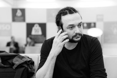 Yakışıklı genç bir Havaalanı lounge telefonunu kullanarak dreadlocks ile.
