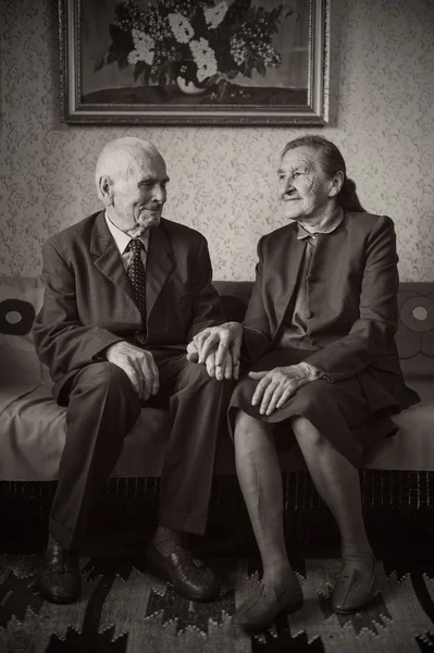 Söta 80 plus år gammal gift par poserar för ett porträtt i deras hus. Love forever koncept. — Stockfoto