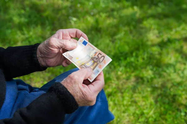 Senior man's hands holding Euro banknote. Struggling pensioners concept. — Stock Photo, Image