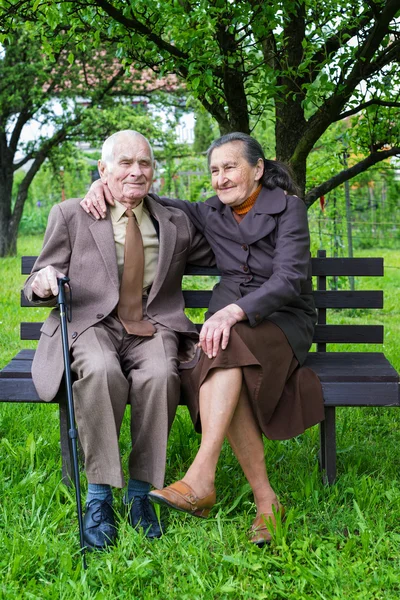 Söta 80 plus år gammal gift par poserar för ett porträtt i deras trädgård. Love forever koncept. — Stockfoto