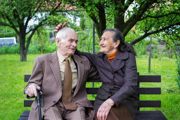 Söta 80 plus år gammal gift par poserar för ett porträtt i deras trädgård. Love forever koncept. — Stockfoto