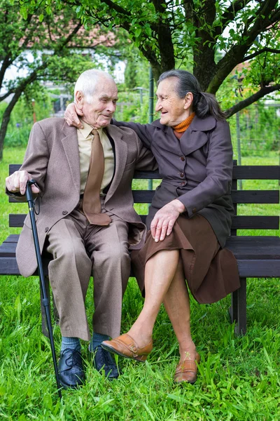 Söta 80 plus år gammal gift par poserar för ett porträtt i deras trädgård. Love forever koncept. — Stockfoto