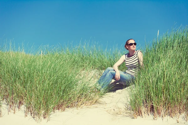 ラスケンタイア、ハリス島、スコットランドのリラックス、晴れた日に眺めの背の高い草の中で砂丘に座っている若い女性 — ストック写真