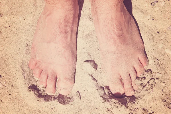 Mannelijke blote voeten in een warme zand op een zonnig strand tijdens vakantie — Stockfoto