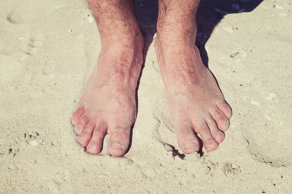 Mannelijke blote voeten in een warme zand op een zonnig strand tijdens vakantie — Stockfoto