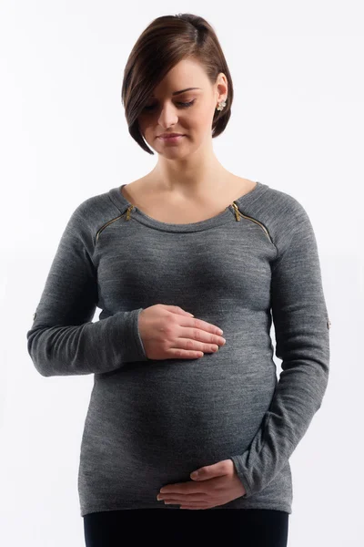 Image of pregnant woman touching her belly with hands on white background — Stock Photo, Image