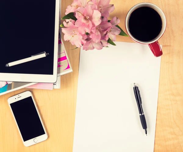 Office tafel met digitale tablet, smartphone leeg vel papier en kopje koffie. Bekijken van boven met kopie ruimte — Stockfoto