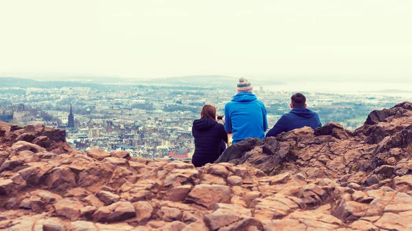 Friends taking images of Edinburgh from top of Arthurs seat, ancient volcano, Scotland, UK, using smartphone — Stock Photo, Image