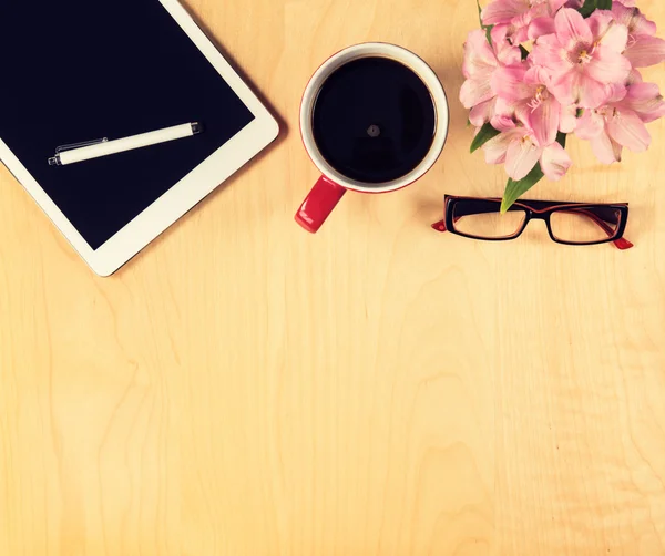 Table de bureau avec tablette numérique, lunettes de lecture et tasse de café. Vue d'en haut avec espace de copie — Photo