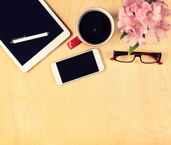 Mesa de oficina con tablet digital, smartphone, vasos de lectura y taza de café. Vista desde arriba con espacio de copia —  Fotos de Stock