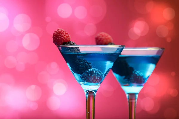 Çilek ile arka plan ışık efektleri ile süslenmiş renkli kokteyller — Stok fotoğraf