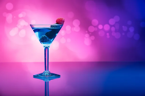 Färgglada drinkar garnerad med bär, bakgrund med ljuseffekter — Stockfoto