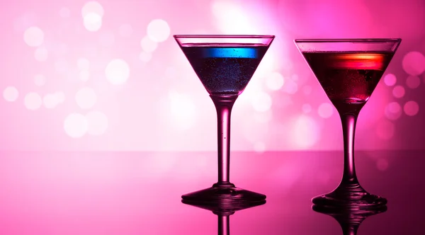 Colourful cocktails on reflective top, with bokeh background — Stock Photo, Image