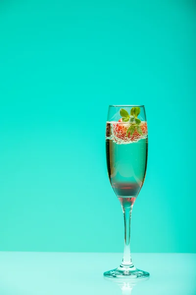 Champagneglas med jordgubbe, studio skott med ljuseffekter — Stockfoto