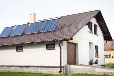 Vakumlu güneş enerjili su ısıtma sistemi bir evin çatı üzerinde.