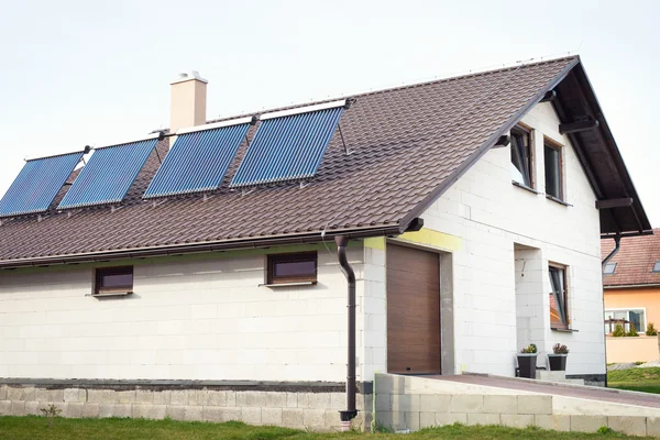 Sistema solar de calentamiento de agua al vacío en el techo de una casa . — Foto de Stock