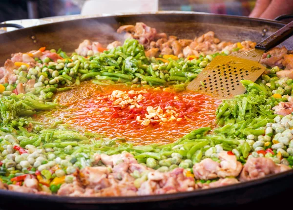 Traditional spanish chicken paella preparation on big pan, outdoors food market — Stock Photo, Image