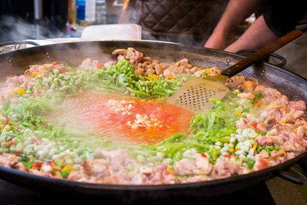 Traditional spanish chicken paella preparation on big pan, outdoors food market — Stock Photo, Image