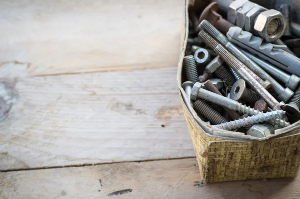 Box of old rusty metal screws on wooden background — Stock Photo, Image