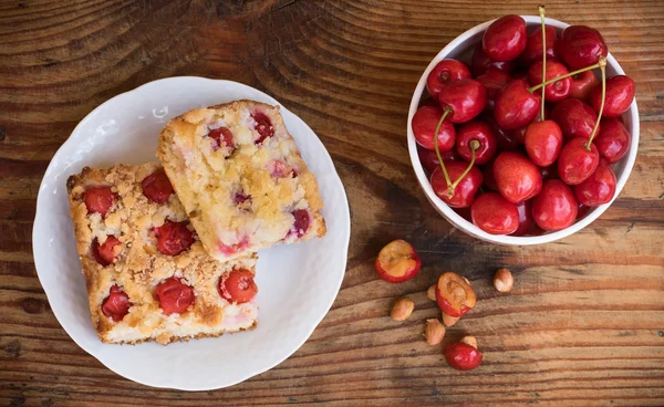 Ripe organic homegrown cherries and cherry cake, on wooden background — Stock Photo, Image