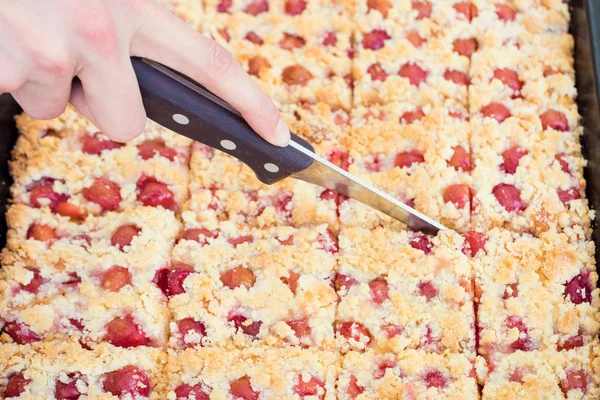 Person cutting sweet homemade crumble cherry pie — Stock Photo, Image