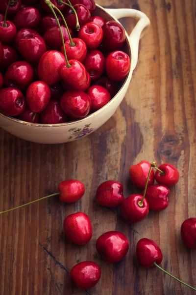 Ripe organic homegrown cherries in a vintage ceramic bowl, on wooden background — Stock Photo, Image