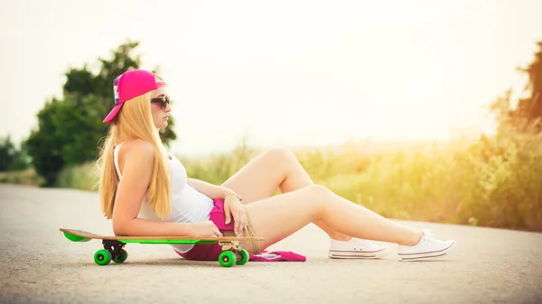 Attraente ragazza hipster adolescente con skateboard, immagine con sunflare — Foto Stock